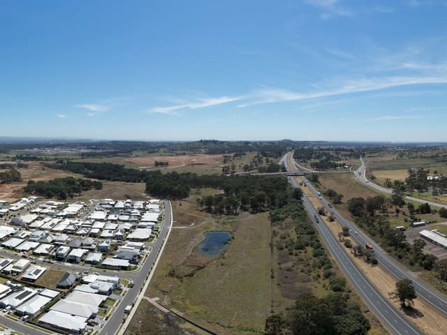 Housing streets beside a divided motorway and surrounding trees.
