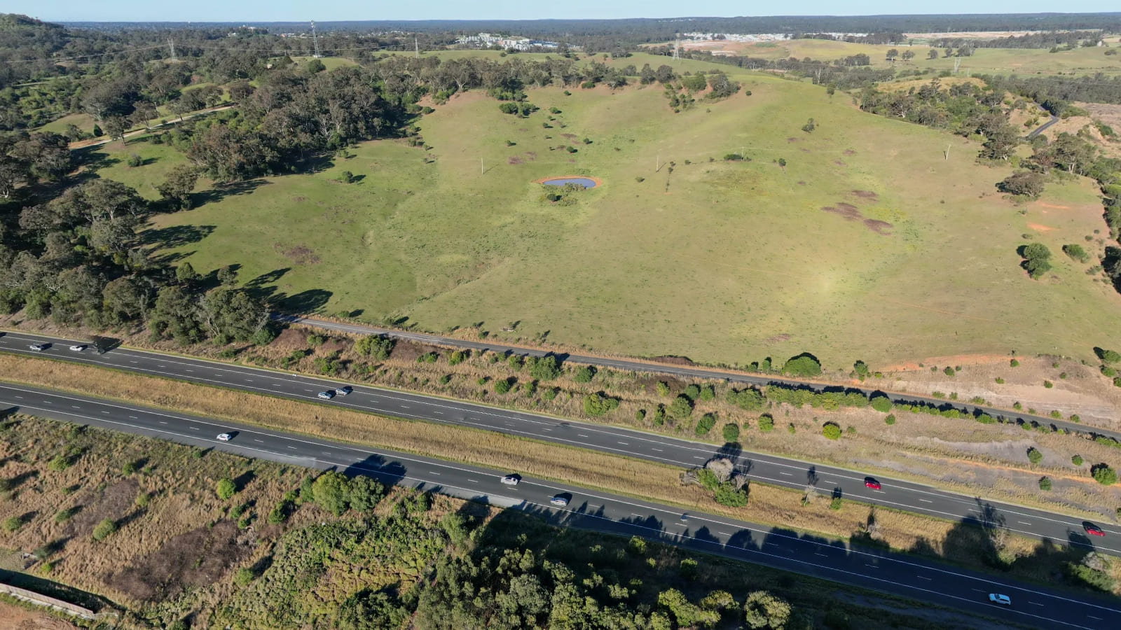 Aerial view of a dual carriageway motorway running through a landscaped cutting.