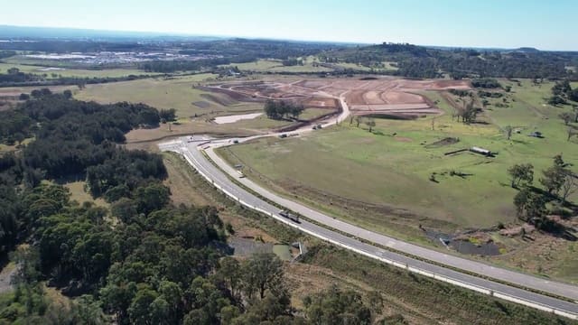 In along the road, over the earthworks being cut for the next stages, and across the paddocks and bush that still edge them.